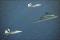 F-22 Raptors and B-2 Spirit in flight over the Pacific near Guam.